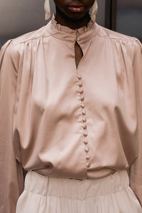 The Mariella silky top featuring band collar with ruched ruffles detailing, long sleeves with single-button cuff. Full-button placket. Relaxed fit.