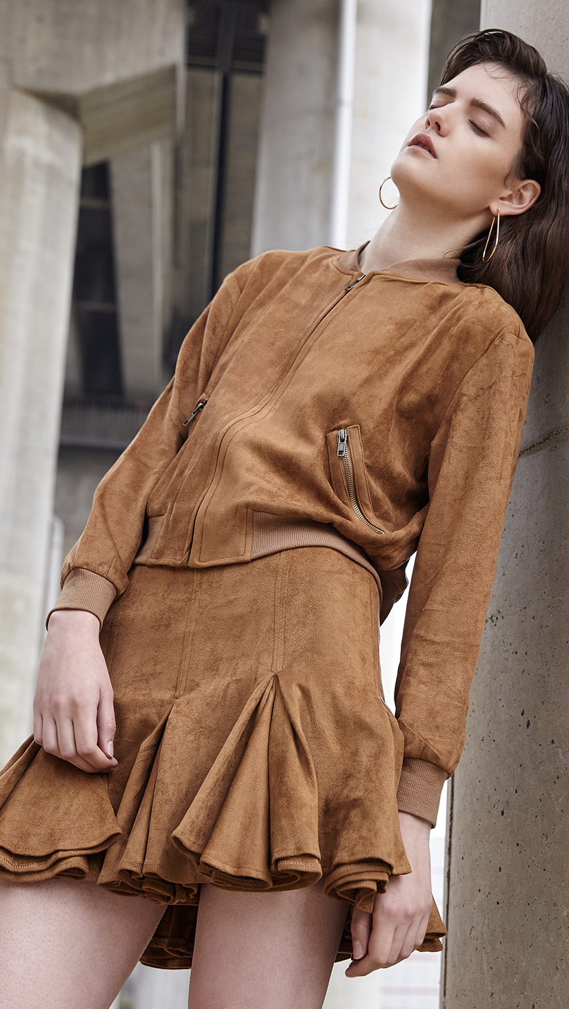 The Meera Suede Set in camel jacket and skirt. Jacket has a single zip closure at front, side pockets with zipped opening, no collars. Skirt has a flared hem with back zip closure. Lightweight. Slim fit.
