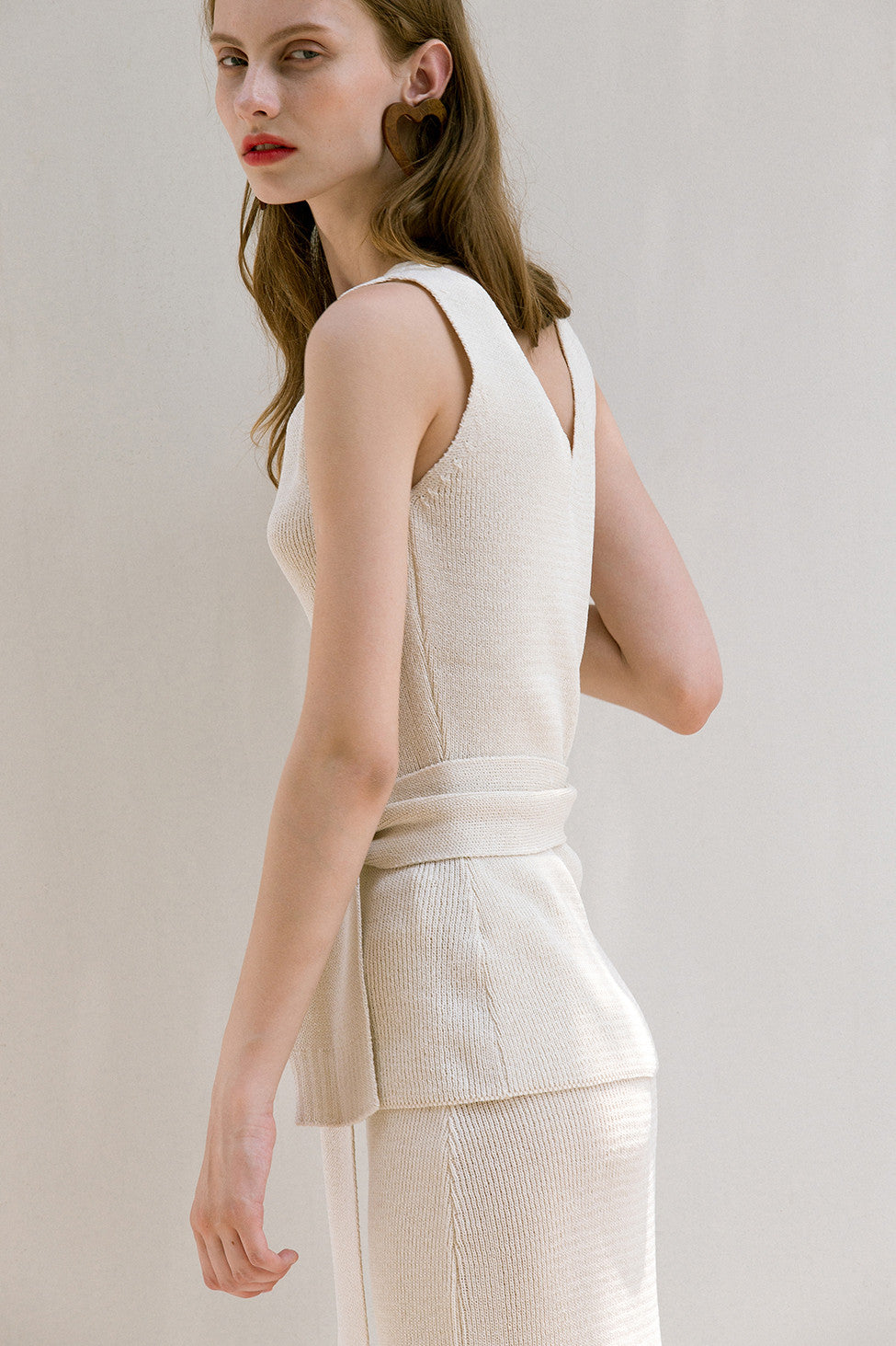 The Mikaela Top in lightweight knitted with V-neckline. Sleeveless. Detachable sash belt. Pull on.