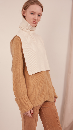 The Muir Turtleneck Knit in ivory with no sleeves. Pull on