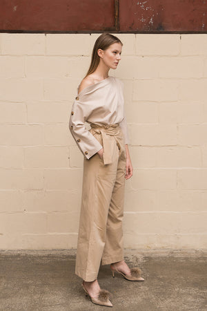 Draped trousers featuring high rise, concealed side zip closure with wrap-look tie adjustment. Darts from back waist. Relaxed straight leg. Full-length. Unlined.