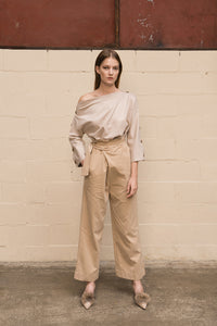 Draped trousers featuring high rise, concealed side zip closure with wrap-look tie adjustment. Darts from back waist. Relaxed straight leg. Full-length. Unlined.