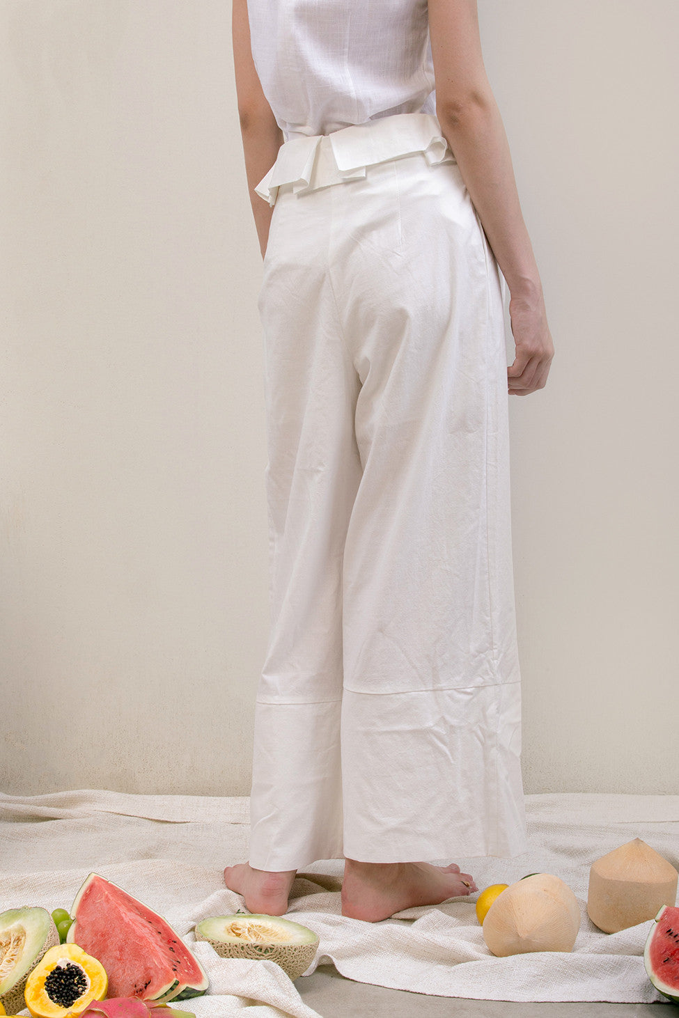 The Noelle Pant in white featuring pleated front with origami design, two slant pockets. Lightweight.