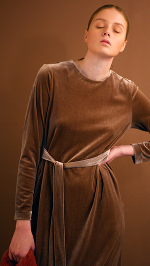 The Palma Dress in lustrous velvet brown. With round neckline, concealed zipper closure at back, long sleeves, attached self-tie strap. Relaxed fit. Stretchy fabric.
