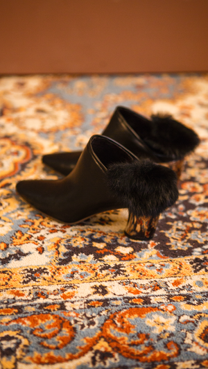 The Ravello Fur Mules in Black. Slide loafers with a pointy toe, padded leather foot bed and rubber soles. Slip on.  