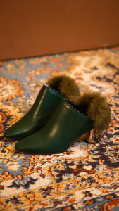 The Ravello Fur Mules in Green. Slide loafers with a pointy toe, padded leather foot bed and rubber soles. Slip on.  