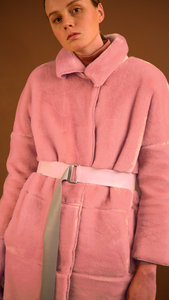 Rosaura Shearling Coat in pink. Super soft, notched collar, dropped shoulder, long sleeve. Snap-button closure at front. Detachable self-tie belt without loops, two slant pockets. Fully lined. Relaxed silhouette.
