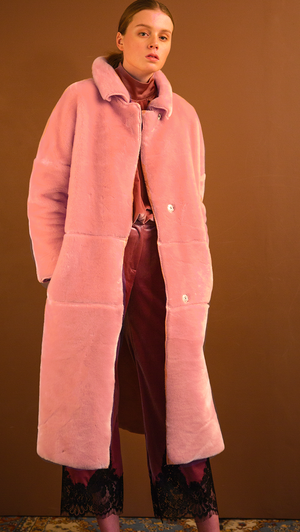 Rosaura Shearling Coat in pink. Super soft, notched collar, dropped shoulder, long sleeve. Snap-button closure at front. Detachable self-tie belt without loops, two slant pockets. Fully lined. Relaxed silhouette.