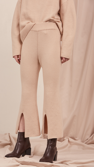 The Roscoe Pant in cream beige. Cropped length with deep V slit, gathered elastic waistband. Slightly dropped crotch. High rise.