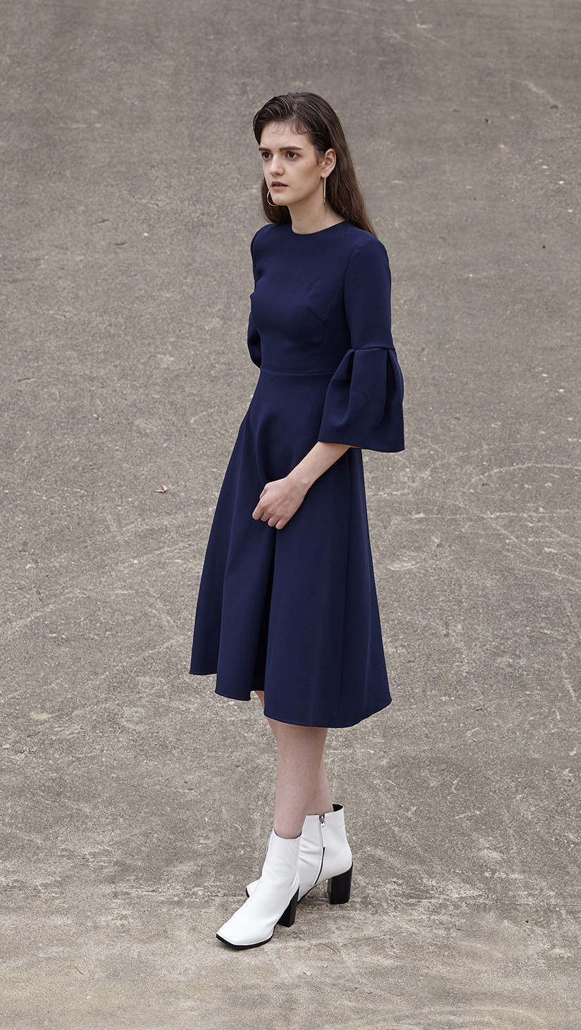 Roxette Dress in navy. With a voluminous flounce sleeves in 3/4 length, round neckline, silk blend insert in contacting collar - bold orange. Below-the-knee length. Hidden zip closure along back. A-line silhouette.