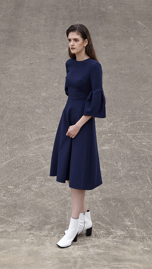 Roxette Dress in navy. With a voluminous flounce sleeves in 3/4 length, round neckline, silk blend insert in contacting collar - bold orange. Below-the-knee length. Hidden zip closure along back. A-line silhouette.