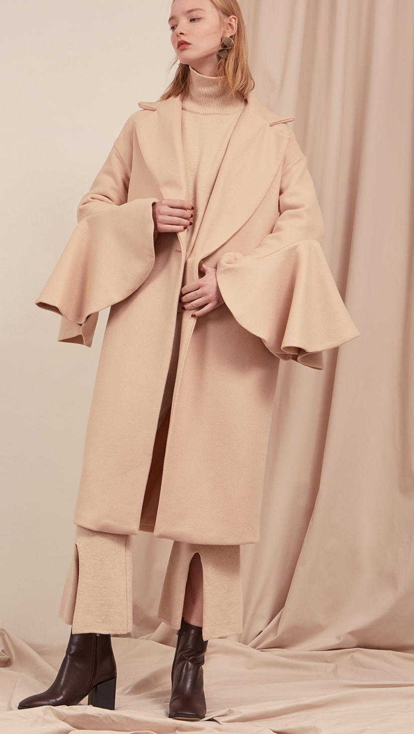 The Ruliette coat styled with gathered wide flare sleeves. With raw-edge ruffled puff sleeves, oversized felt-faced point collar, convertible notch lapel, back drop shoulders, one button closure at front, on-seam vertical slip pockets. Fully lined. Mid-weight.