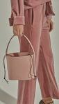 Seed Bucket bag in Pale Pink. Main compartment with adjustable strap, detachable shoulder strap, interior pocket with zipper compartment. Structured bottom.