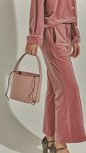 Seed Bucket bag in Pale Pink. Main compartment with adjustable strap, detachable shoulder strap, interior pocket with zipper compartment. Structured bottom.