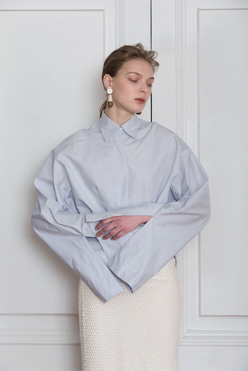 The Selina Shirt in Blue featuring classic button down with full length wide sleeves. Button closure at cuffs. Dropped Shoulder.