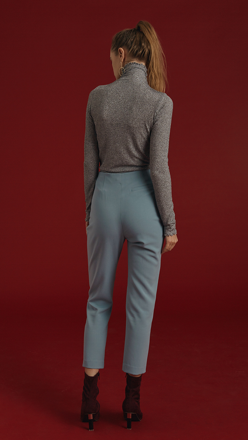 The Siena Pant is high waisted, cropped carrot trousers with gold hardware detailing in Airy Blue. Concealed zip closure along side. No pockets. 