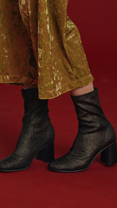 Stretch shiny fabric ankle boots in gold metallic. Matching topstitching detail in the centre. Pull-tab at the back. Rounded toe. Rounded heel. Ankle length.