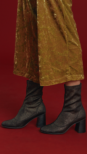 Stretch shiny fabric ankle boots in gold metallic. Matching topstitching detail in the centre. Pull-tab at the back. Rounded toe. Rounded heel. Ankle length.