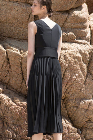 The Simma Dress in Black, featuring v-neckline, sleeveless, removable wide belt, pleated skirt. Concealed zip fastening at the back. 