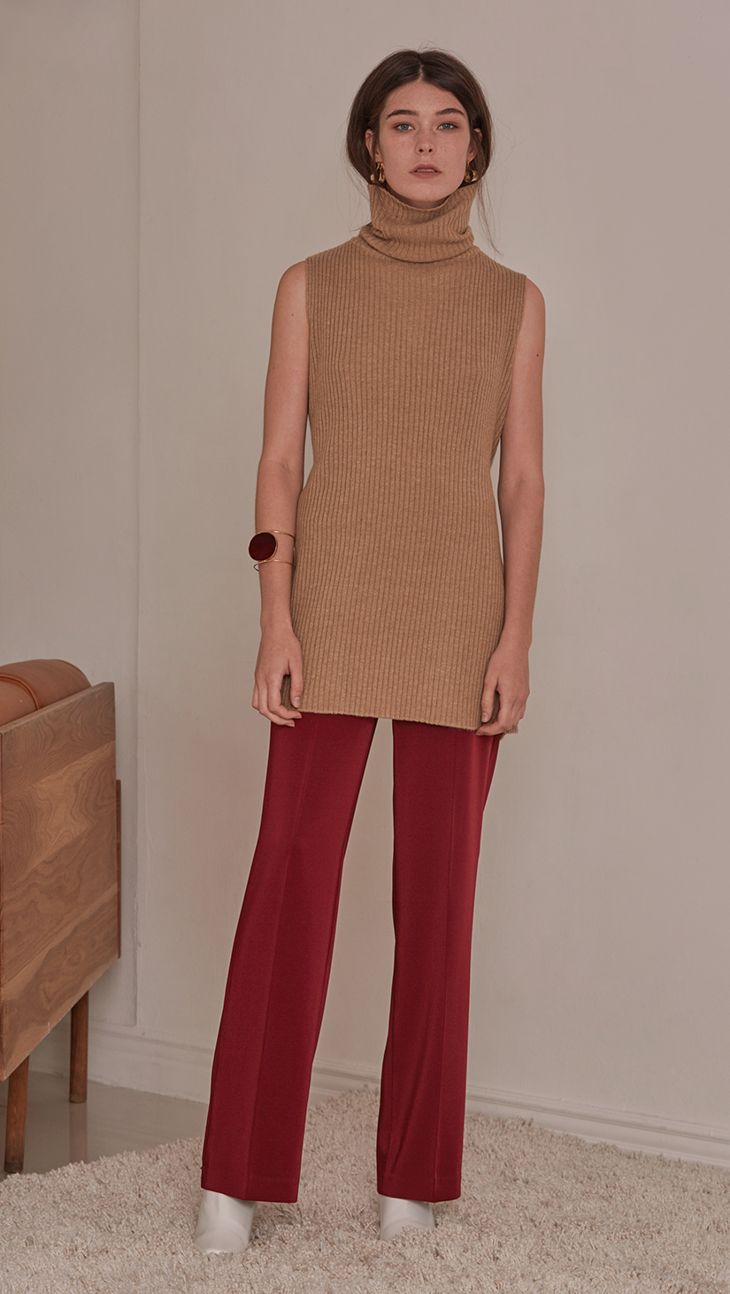 Sofia Sweater, a knit sweater in brown sugar. Turtleneck long sleeve sweater in wool cashmere blend. Vertical ribbing detail, sleeveless and open back with self-tied. Designed to be loose fit.