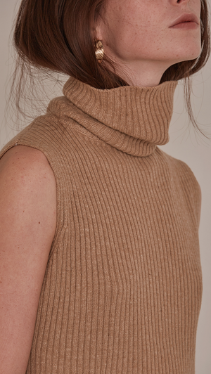 Sofia Sweater, a knit sweater in brown sugar. Turtleneck long sleeve sweater in wool cashmere blend. Vertical ribbing detail, sleeveless and open back with self-tied. Designed to be loose fit.
