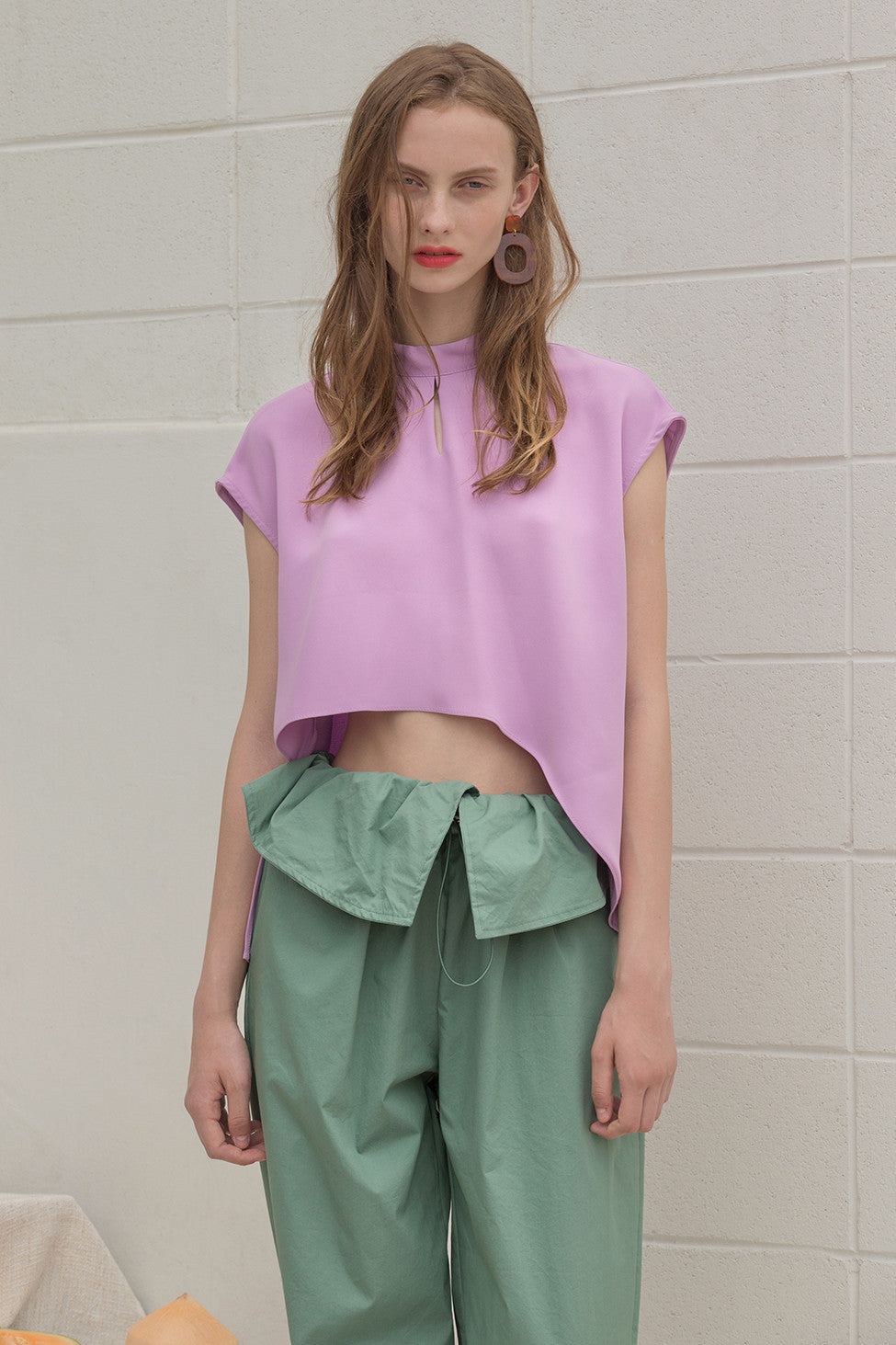 The Sofie Top in Lilac featuring cap short sleeves, asymmetric cropped hem, keyhole closure at back. 