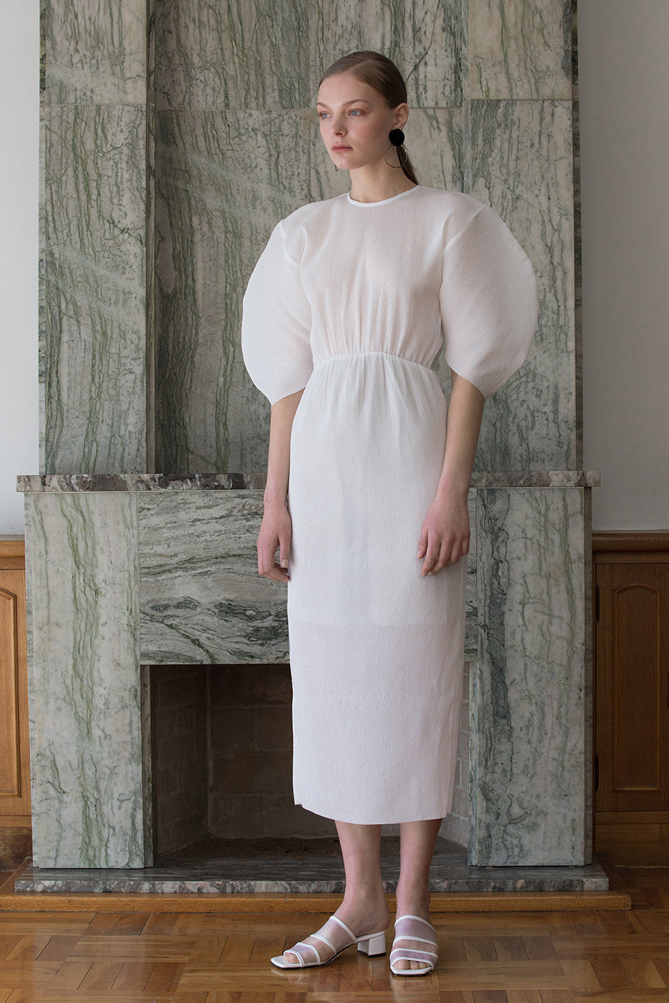 The Soliel Dress in White, featuring raglan bubble half sleeves, waistline with drawstring for cinching, concealed zip fastening at the back. Fitted at waist. Back slits.