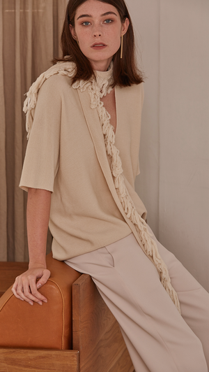Short sleeved pullover with deep v-neck in ivory wool. A matching tassel scarf gathers. Pull on. Designed to be loose fit.