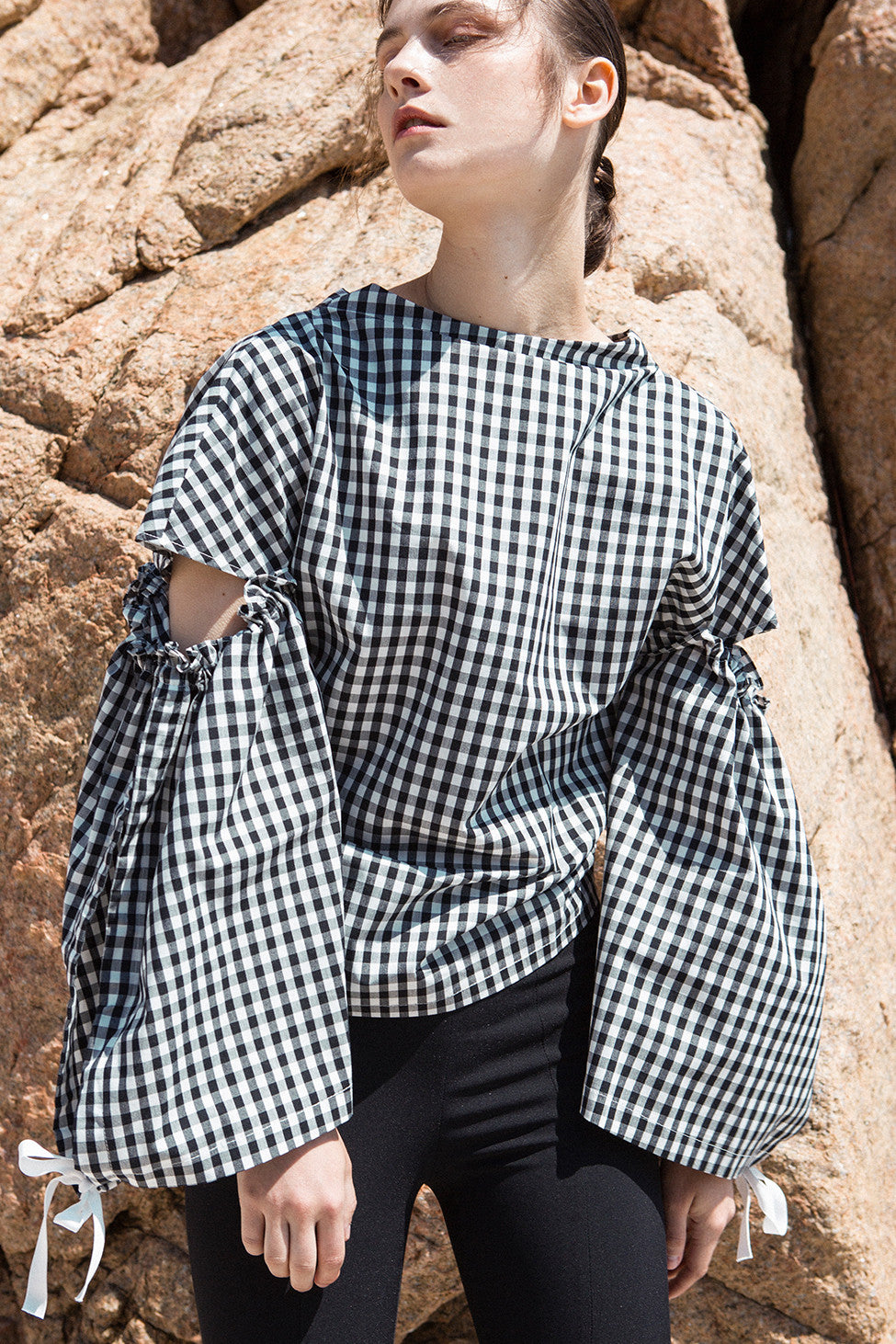 The Tabitha Top in black gingham stripes featuring boat neckline, open-back with drawstring tape back tie. Gathered long wide sleeves. 