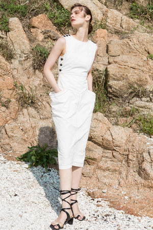 The Tamiko Dress in White, featuring round neckline, sleeveless with button down detailing, open-back with snap button closure. Structured silhouette. Concealed zip fastening at the back.