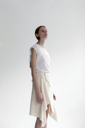 The Vernon Skirt in Ivory featuring cascading ruffle down front. Asymmetrical hem. Wrapover front panel with two snap button. Front vent.