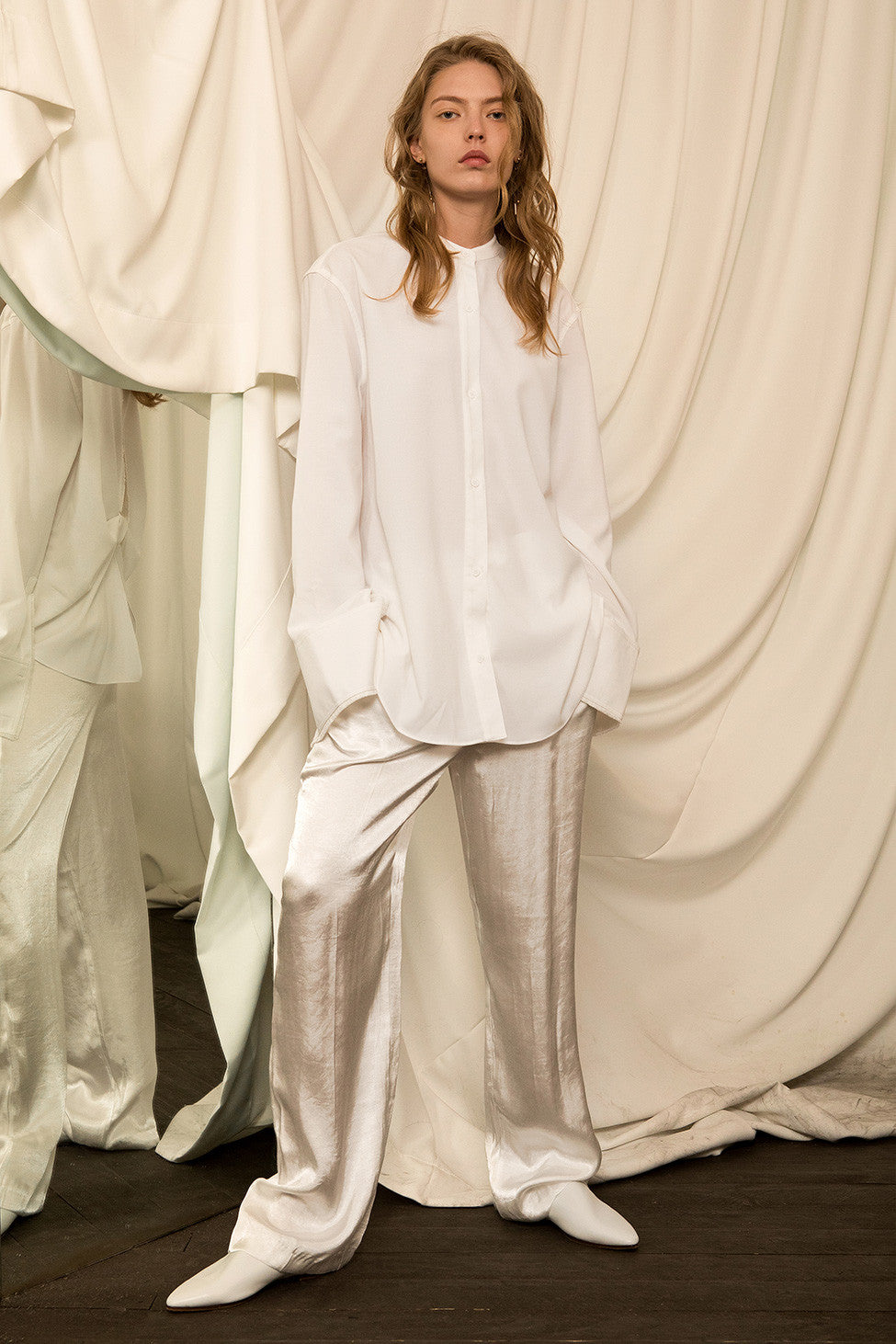 The Yuku Top in Off White, featuring deep V-slits with back knot, tassel detailing at cuffs and slits, concealed button down placket. Dropped shoulder. 