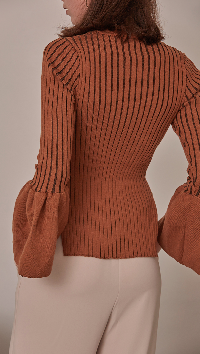 Etre Sweater in Brown. Oversized puffs on exaggerated cuffs, rib knit in the avant-grade silhouette. Voluminous bell sleeves in cropped length top with side slit. Rounded hem. Super soft feel. Designed to skim the body. The slim fit makes it a natural for laye